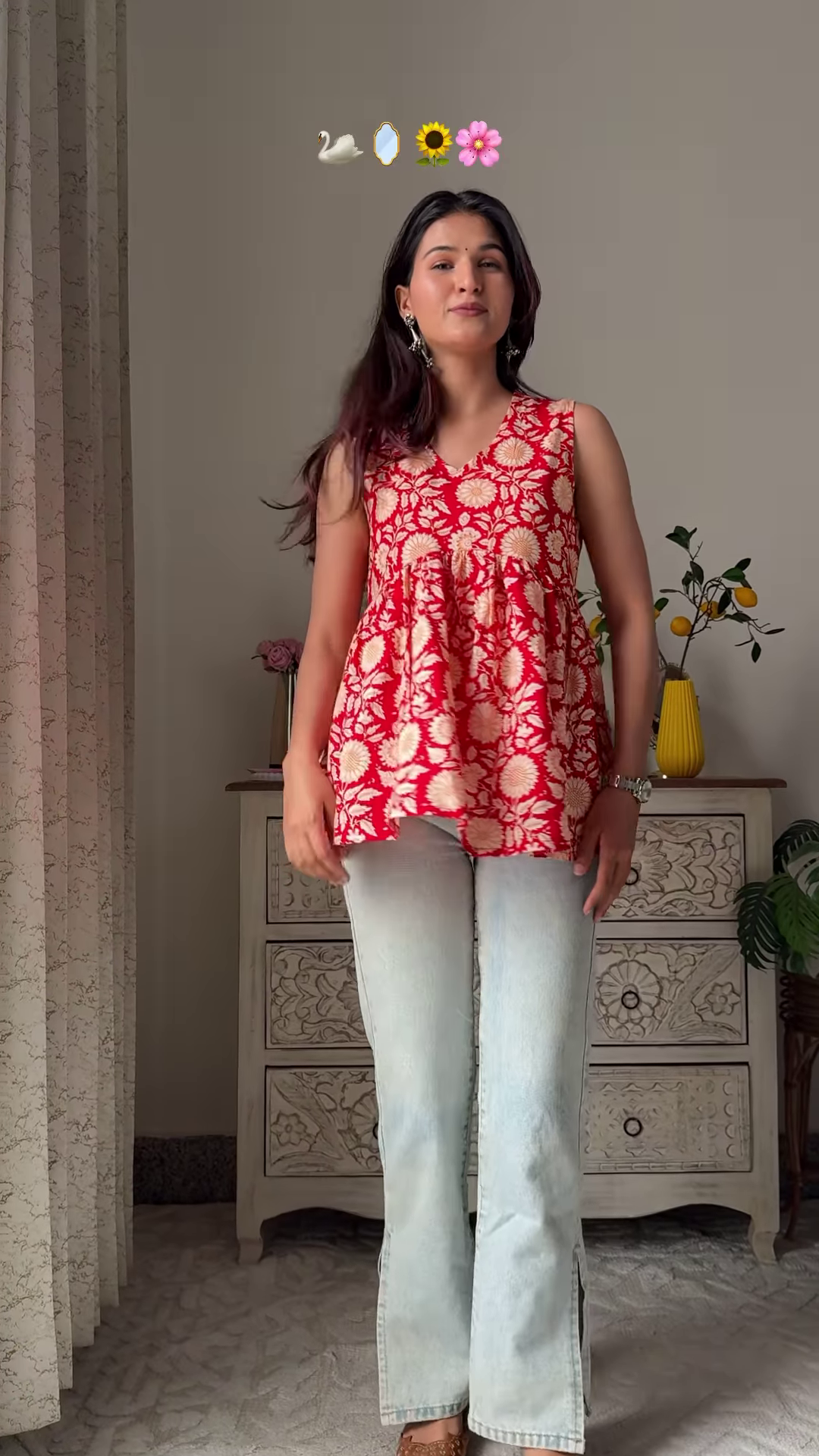 Women’s Sleeveless Red Floral Top with Light Blue Flared Jeans – Indo-Western Casualwear Styled with Vintage Decor Backdrop